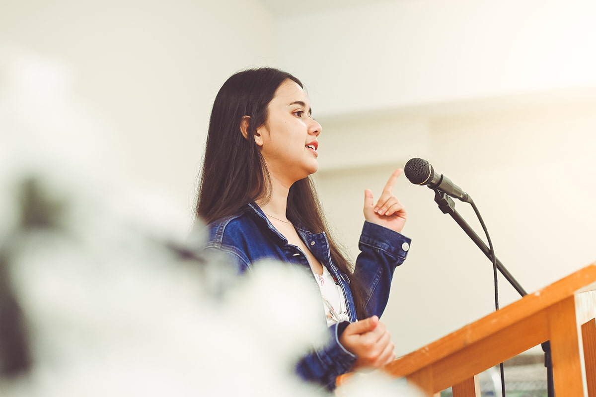 Teen girl standing in front of a microphone