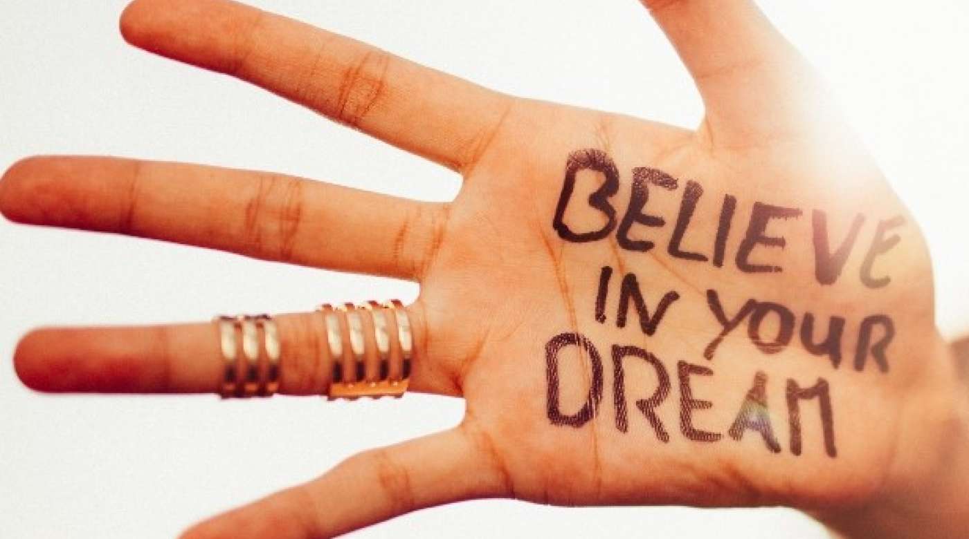 Hand with "believe in your dream" written on the palm